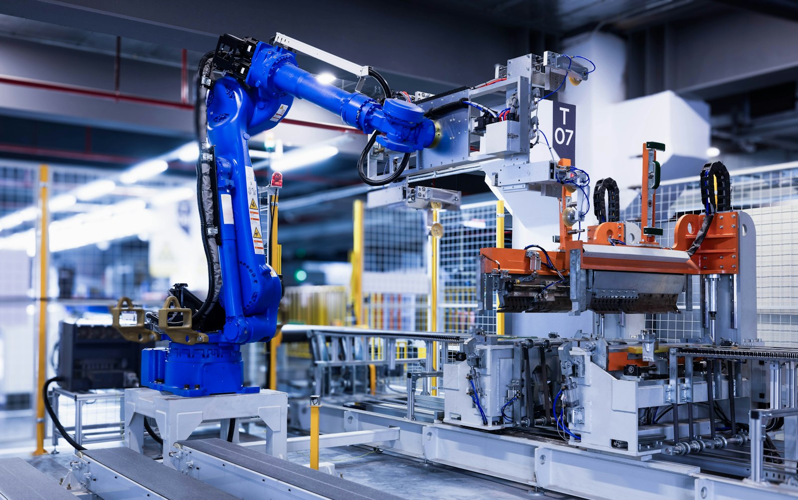 Blue industrial robot arm on a factory assembly line