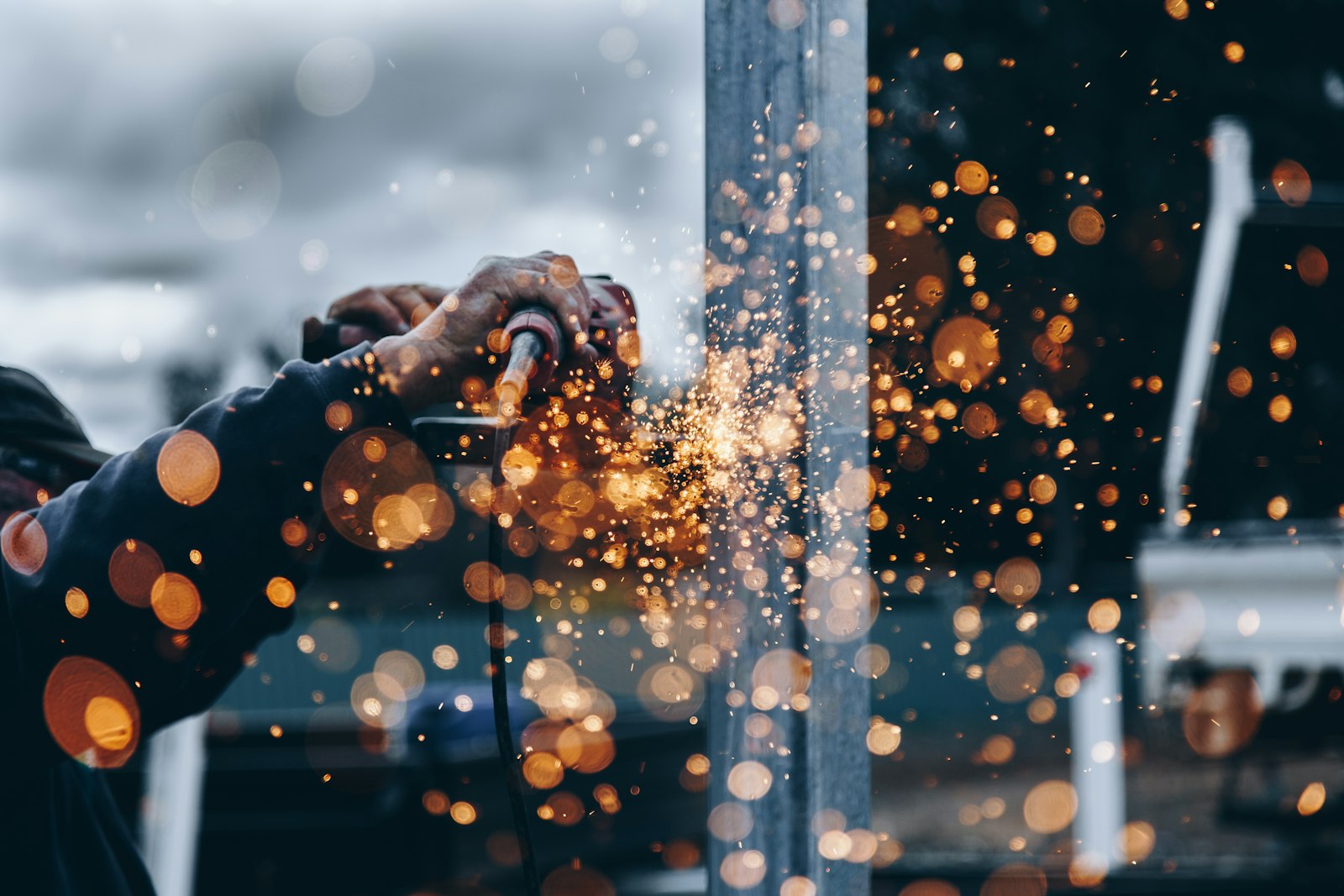 Field technician grinding metal on an outdoor industrial site
